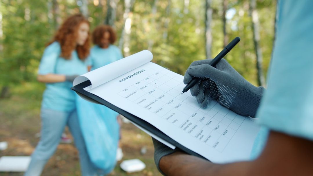 En person som bockar av ett schema för volontärarbete vid ett utomhusevent.